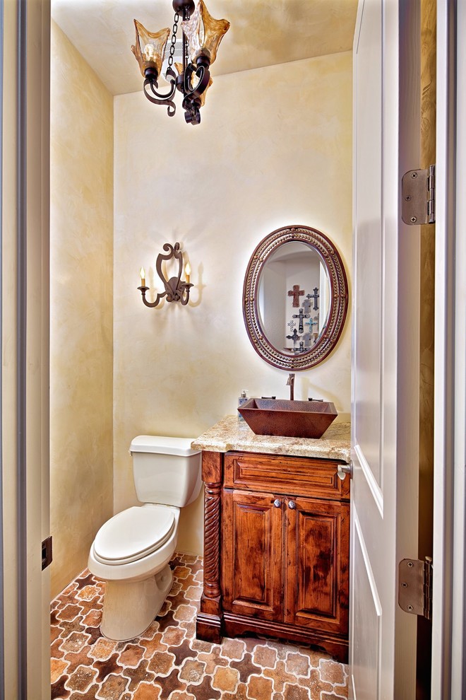 Inredning av ett medelhavsstil badrum, med ett fristående handfat, en toalettstol med separat cisternkåpa och beige väggar