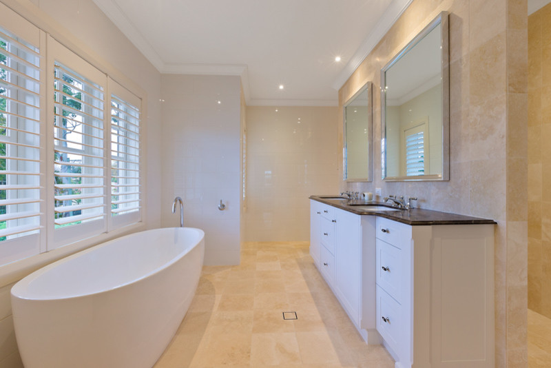 Modernes Badezimmer En Suite mit weißen Schränken, freistehender Badewanne, Duschnische, Wandtoilette, beigen Fliesen, Steinfliesen, beiger Wandfarbe, Travertin und Unterbauwaschbecken in Sydney