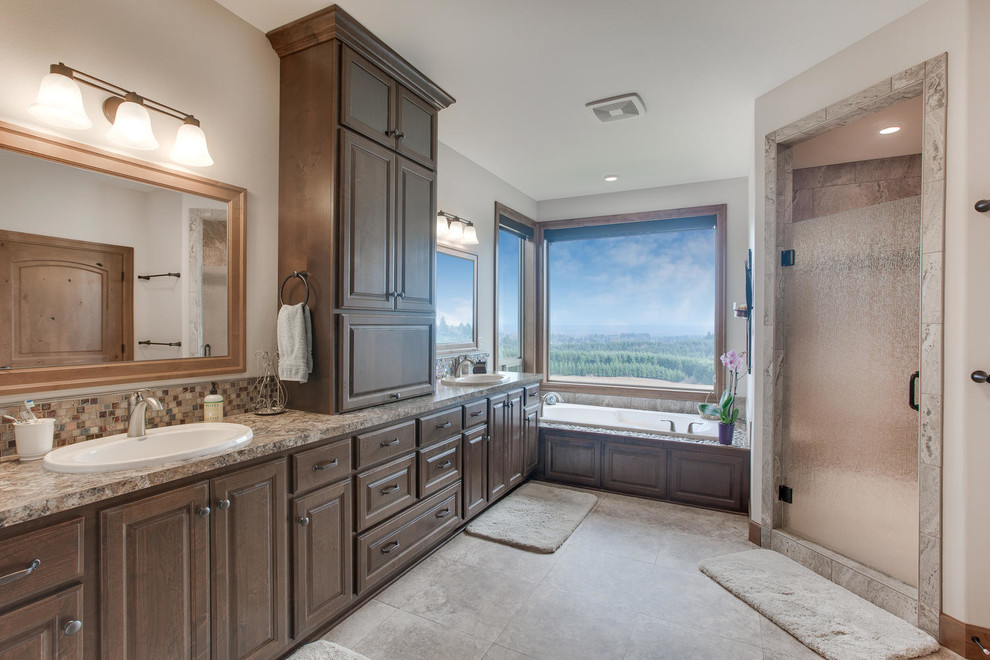 Imagen de cuarto de baño principal de estilo americano grande con lavabo encastrado, puertas de armario de madera en tonos medios, bañera empotrada y paredes beige