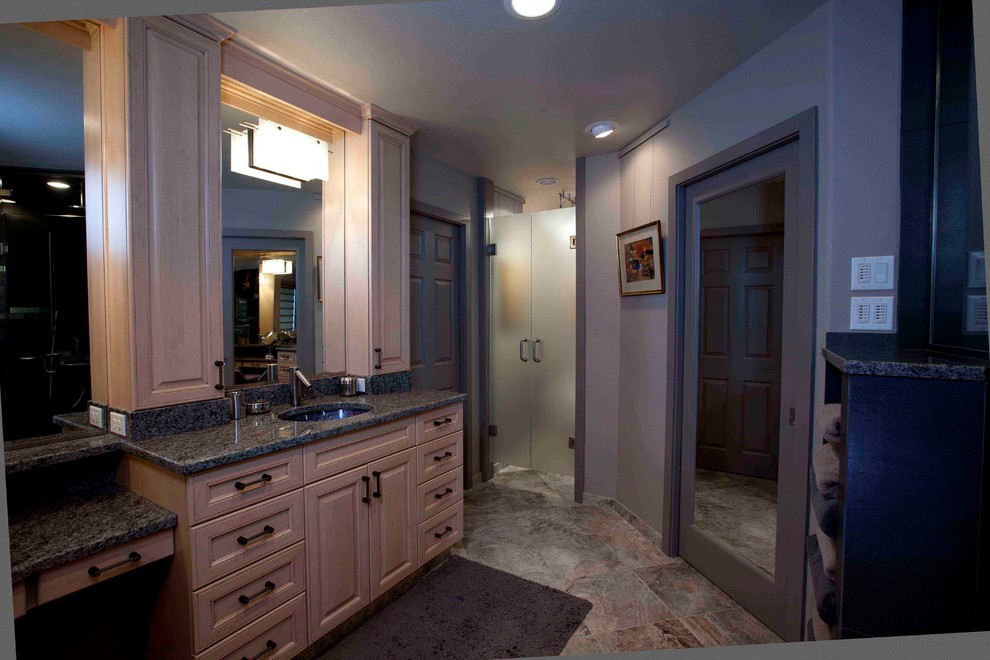 Example of a large transitional master gray tile and porcelain tile travertine floor bathroom design in Seattle with an undermount sink, raised-panel cabinets, light wood cabinets, granite countertops, a two-piece toilet and gray walls