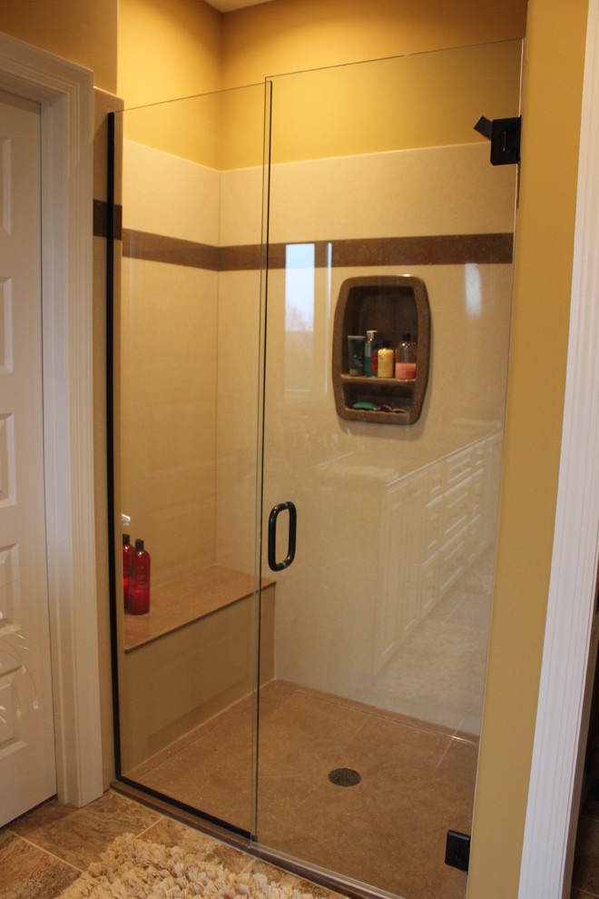 Réalisation d'une salle de bain principale tradition de taille moyenne avec un lavabo intégré, un placard avec porte à panneau surélevé, des portes de placard beiges, un plan de toilette en onyx, un mur jaune et un sol en carrelage de céramique.