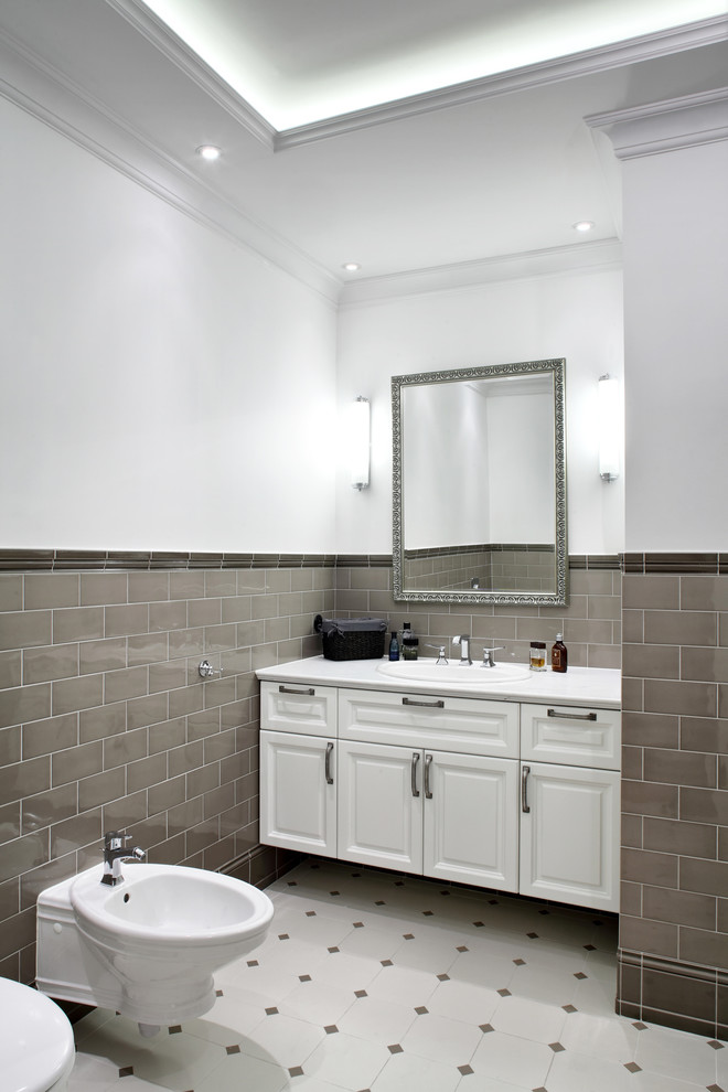 Inspiration för klassiska badrum, med ett nedsänkt handfat, möbel-liknande, vita skåp, marmorbänkskiva, ett fristående badkar, en dusch i en alkov, en vägghängd toalettstol, beige kakel och porslinskakel