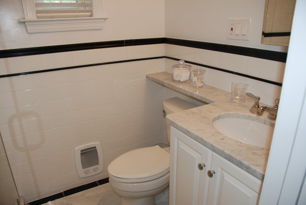 ワシントンD.C.にあるお手頃価格の小さなトラディショナルスタイルのおしゃれなバスルーム (浴槽なし) (レイズドパネル扉のキャビネット、白いキャビネット、サブウェイタイル、大理石の洗面台、アルコーブ型シャワー、分離型トイレ、黒いタイル、モノトーンのタイル、白いタイル、白い壁、磁器タイルの床、アンダーカウンター洗面器) の写真