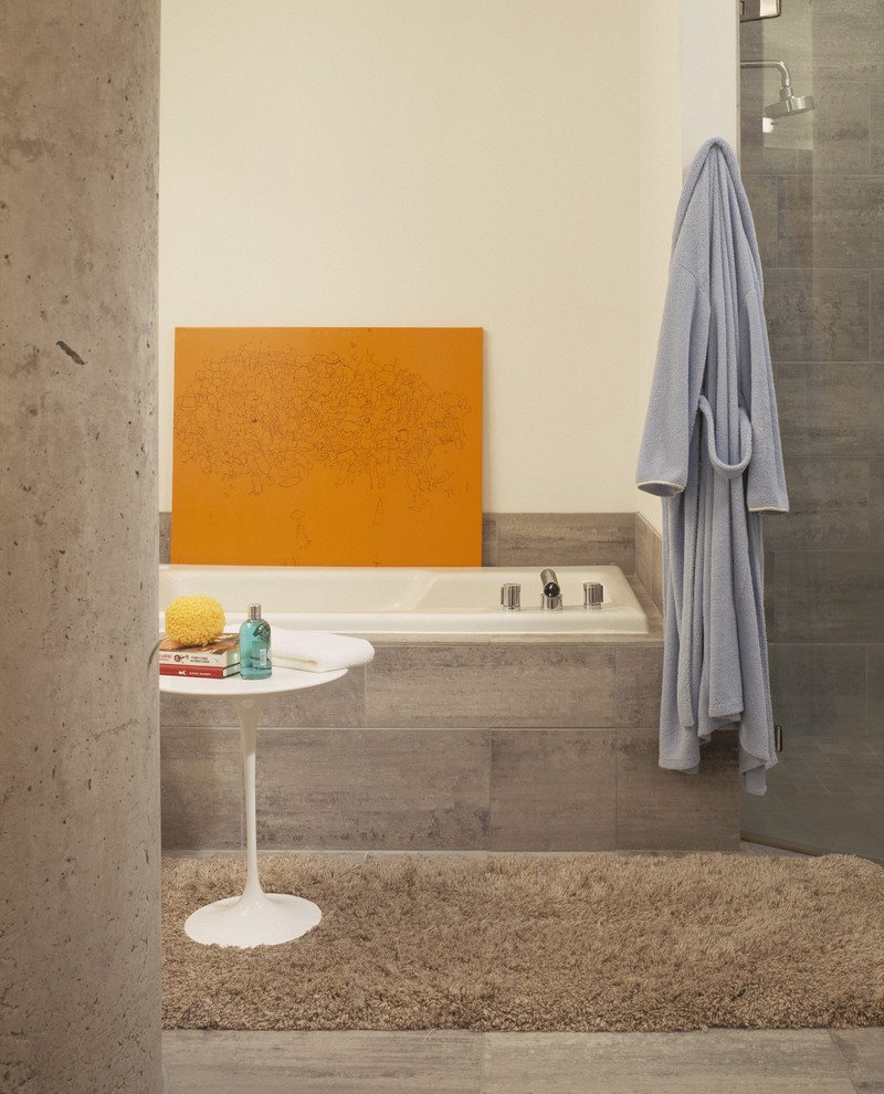 Réalisation d'une salle de bain design avec une baignoire posée et du carrelage en pierre calcaire.