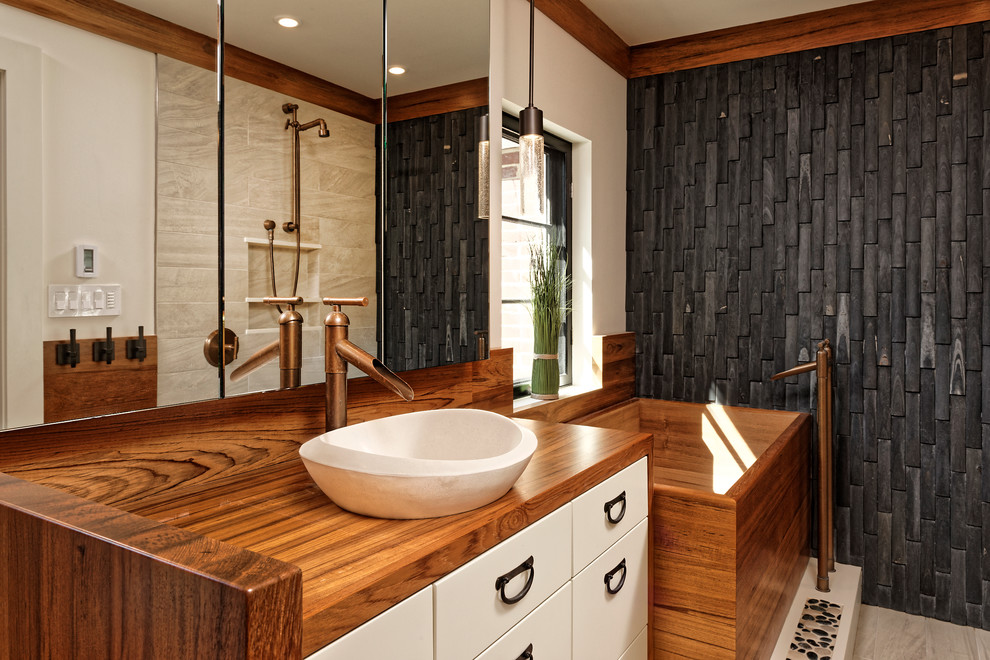 ワシントンD.C.にある中くらいなアジアンスタイルのおしゃれな浴室 (フラットパネル扉のキャビネット、白いキャビネット、黒いタイル、石タイル、ベッセル式洗面器、木製洗面台、和式浴槽) の写真