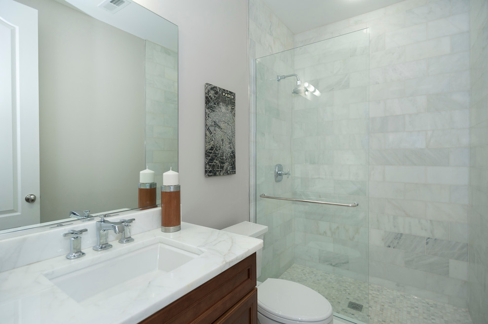 Tub/shower combo - mid-sized transitional 3/4 white tile and stone slab mosaic tile floor tub/shower combo idea in DC Metro with white walls, an undermount sink, marble countertops, shaker cabinets, medium tone wood cabinets and a two-piece toilet