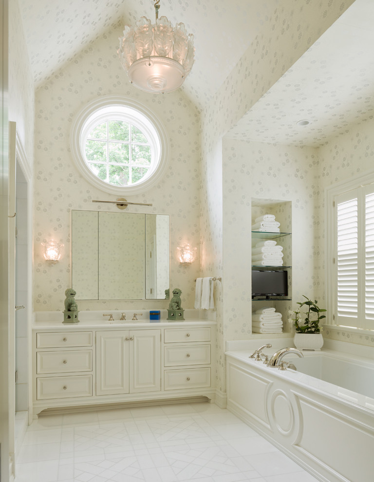Modelo de cuarto de baño tradicional con armarios con paneles con relieve, puertas de armario blancas y bañera empotrada