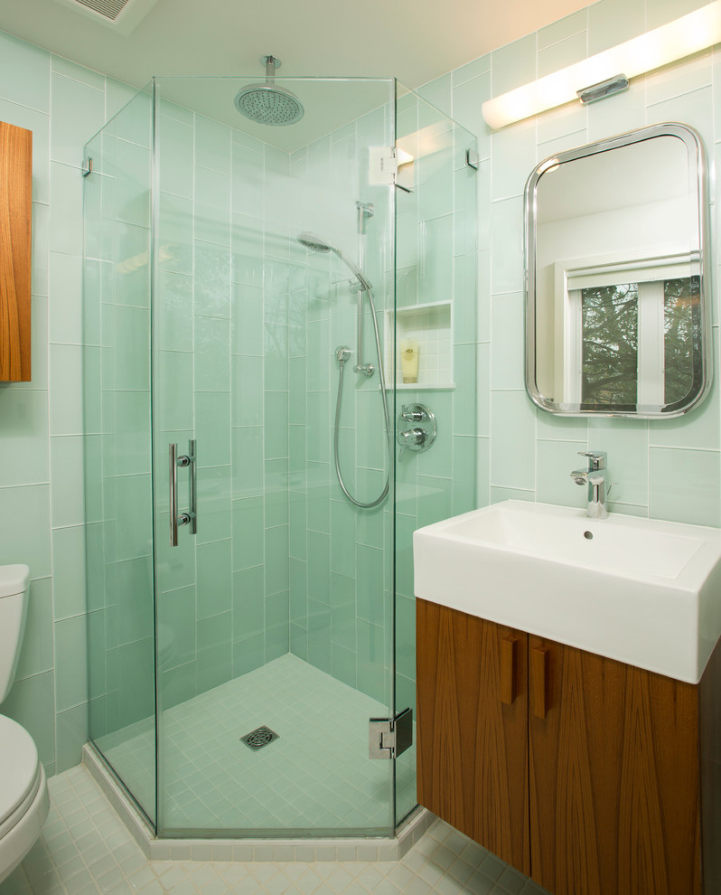 Eklektisk inredning av ett mellanstort badrum med dusch, med släta luckor, skåp i mellenmörkt trä, en hörndusch, en toalettstol med separat cisternkåpa, blå kakel, glaskakel, blå väggar, klinkergolv i keramik och ett fristående handfat