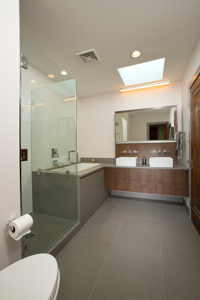 Inspiration for a large modern ensuite bathroom in DC Metro with flat-panel cabinets, brown cabinets, a walk-in shower, a one-piece toilet, ceramic tiles, white walls, ceramic flooring, a submerged bath, grey tiles, a vessel sink and solid surface worktops.
