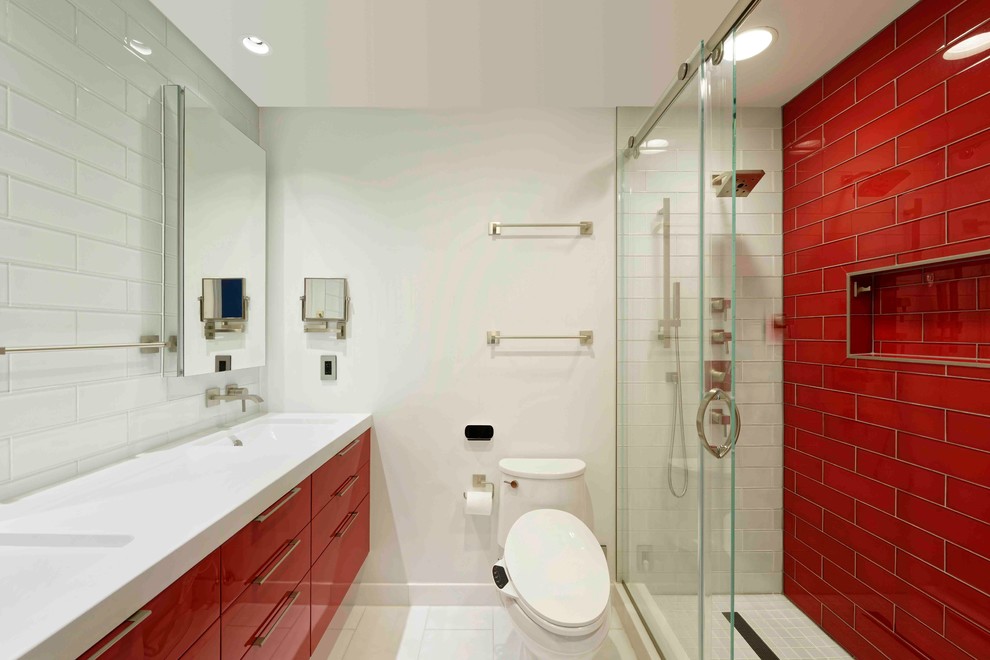 Foto på ett litet funkis badrum för barn, med släta luckor, röda skåp, en dusch i en alkov, en toalettstol med hel cisternkåpa, röd kakel, tunnelbanekakel, vita väggar, klinkergolv i porslin, ett undermonterad handfat och bänkskiva i kvarts