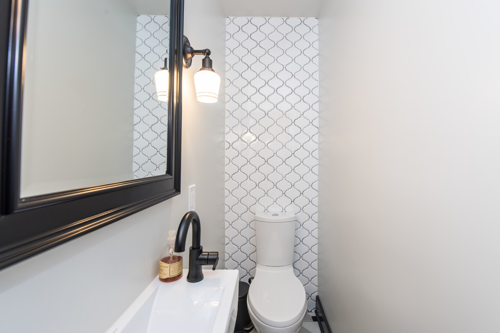 Inredning av ett klassiskt litet badrum med dusch, med en toalettstol med separat cisternkåpa, grå kakel, porslinskakel, beige väggar, mosaikgolv och ett väggmonterat handfat