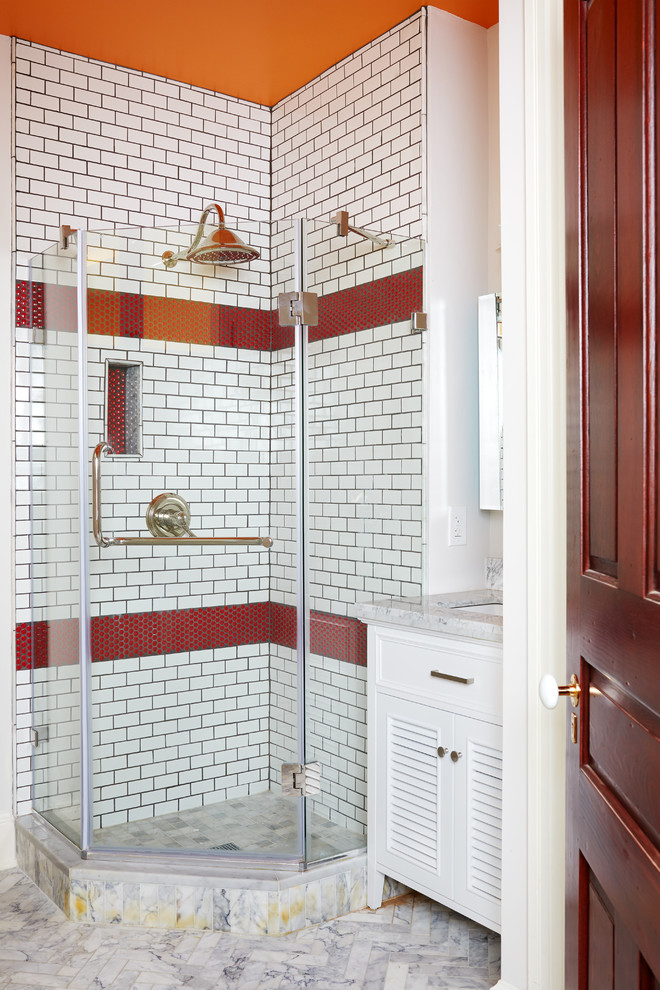 This is an example of a bohemian ensuite bathroom in DC Metro with louvered cabinets, white cabinets, a corner shower, white tiles, ceramic tiles, orange walls, marble flooring, a console sink, marble worktops and a hinged door.