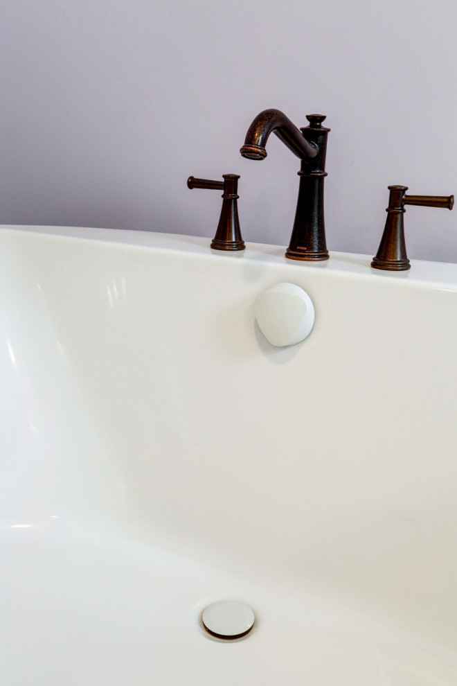 Idéer för mellanstora amerikanska beige en-suite badrum, med beige skåp, ett fristående badkar, en dusch i en alkov, lila väggar, vinylgolv, ett undermonterad handfat, marmorbänkskiva, brunt golv och dusch med gångjärnsdörr