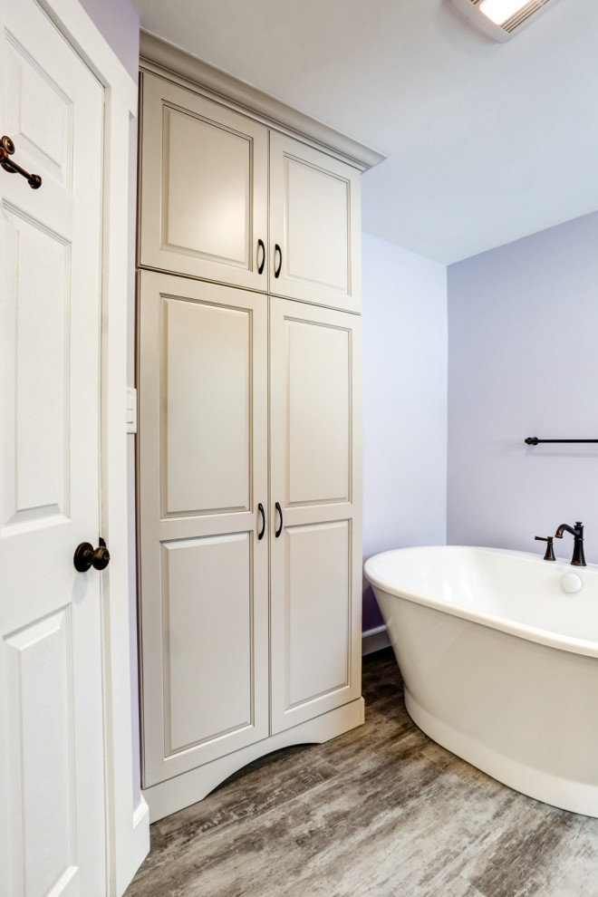 Inredning av ett amerikanskt mellanstort beige beige en-suite badrum, med beige skåp, ett fristående badkar, en dusch i en alkov, lila väggar, vinylgolv, ett undermonterad handfat, marmorbänkskiva, brunt golv och dusch med gångjärnsdörr