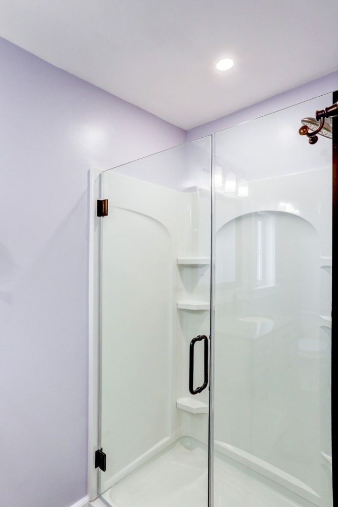 Idéer för ett mellanstort amerikanskt beige en-suite badrum, med beige skåp, ett fristående badkar, en dusch i en alkov, lila väggar, vinylgolv, ett undermonterad handfat, marmorbänkskiva, brunt golv och dusch med gångjärnsdörr