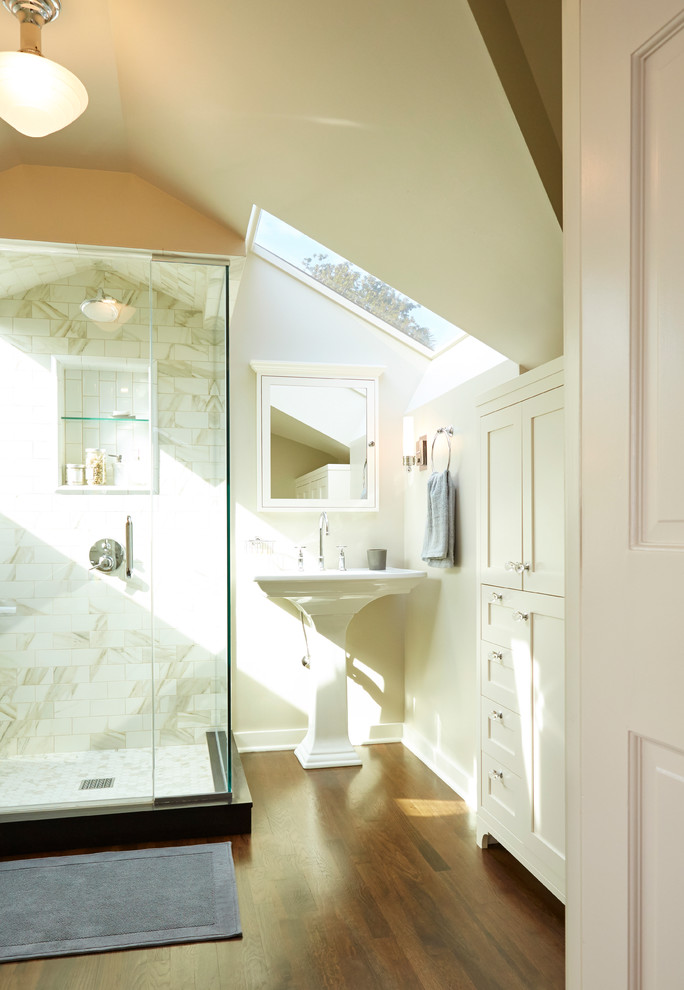 Esempio di una stanza da bagno tradizionale con lavabo a colonna, ante in stile shaker, ante bianche, piastrelle bianche, pareti beige e parquet scuro