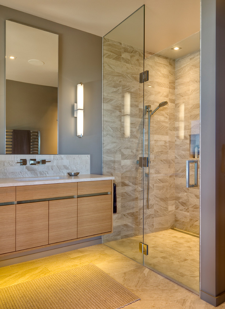Свежая идея для дизайна: большая главная ванная комната в современном стиле с плоскими фасадами, светлыми деревянными фасадами, душем без бортиков, серой плиткой, каменной плиткой, серыми стенами, мраморным полом, врезной раковиной, мраморной столешницей, серым полом и душем с распашными дверями - отличное фото интерьера