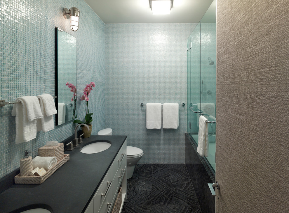 Modelo de cuarto de baño actual con bañera empotrada, combinación de ducha y bañera, baldosas y/o azulejos azules y baldosas y/o azulejos en mosaico