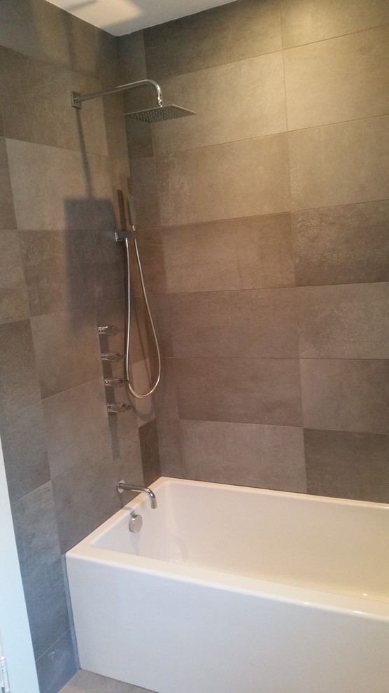 Exemple d'une salle d'eau moderne de taille moyenne avec une baignoire en alcôve, un combiné douche/baignoire, un carrelage gris, des carreaux de porcelaine, un mur gris et une cabine de douche avec un rideau.