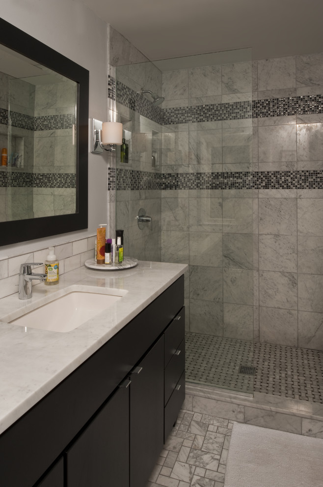 Exemple d'une salle de bain principale tendance de taille moyenne avec un placard à porte plane, des portes de placard noires, une douche à l'italienne, WC à poser, un carrelage blanc, des carreaux de céramique, un mur gris, un sol en marbre, un lavabo encastré et un plan de toilette en quartz.