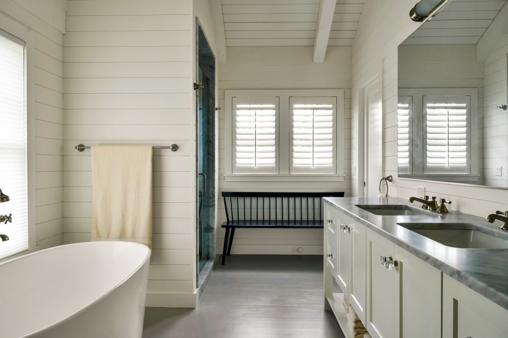 Diseño de cuarto de baño principal costero de tamaño medio con armarios con paneles lisos, puertas de armario blancas, encimera de mármol y encimeras grises