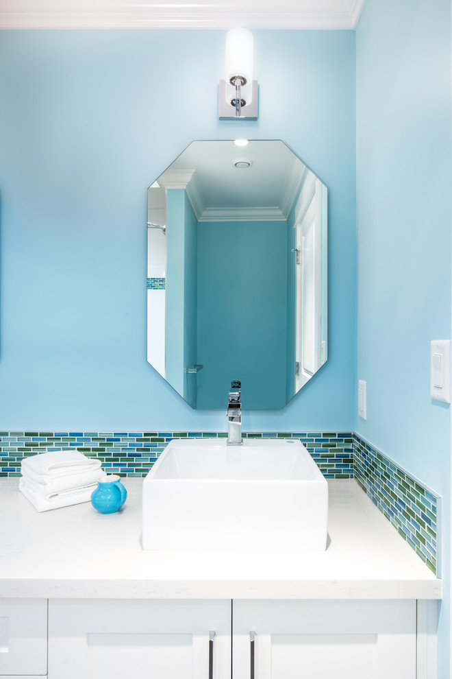 Cette photo montre une salle de bain tendance de taille moyenne pour enfant avec un placard à porte shaker, des portes de placard blanches, une baignoire posée, WC séparés, un carrelage multicolore, un carrelage en pâte de verre, un mur bleu, un sol en carrelage de porcelaine, une vasque et un plan de toilette en quartz modifié.