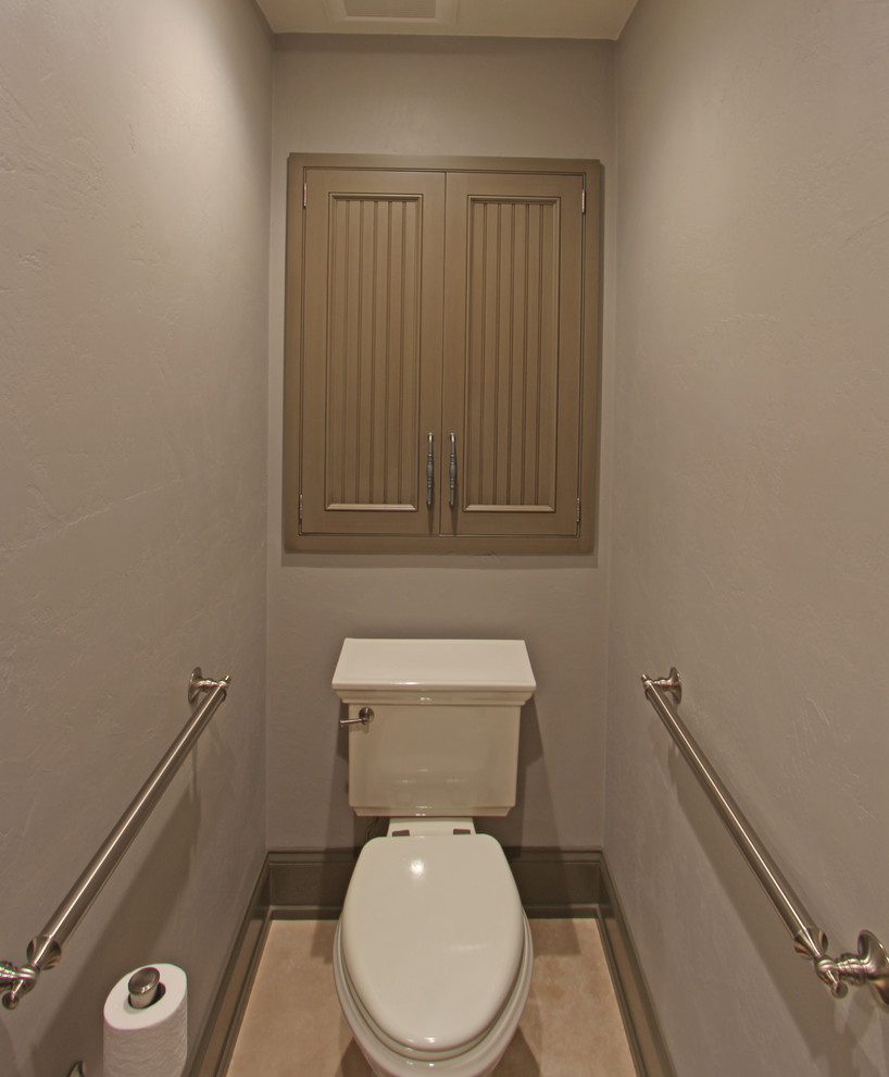 Cette photo montre un grand WC et toilettes chic avec un placard à porte affleurante, des portes de placard beiges, WC séparés, un carrelage gris, du carrelage en travertin, un mur gris, un sol en travertin, un lavabo encastré, un plan de toilette en granite et un sol beige.
