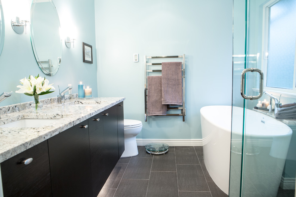 Идея дизайна: главная ванная комната среднего размера в классическом стиле с врезной раковиной, плоскими фасадами, темными деревянными фасадами, мраморной столешницей, отдельно стоящей ванной, угловым душем, раздельным унитазом, коричневой плиткой, керамогранитной плиткой, синими стенами и полом из керамогранита