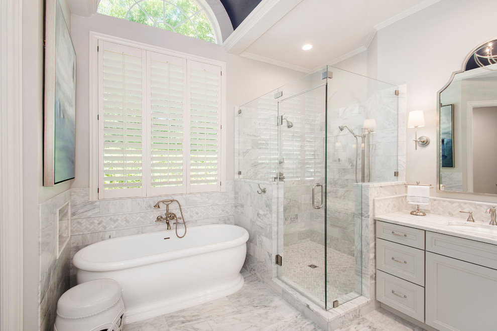 Inspiration for a mid-sized timeless master gray tile and marble tile marble floor and gray floor bathroom remodel in Dallas with recessed-panel cabinets, gray cabinets, a one-piece toilet, white walls, an undermount sink, marble countertops and a hinged shower door