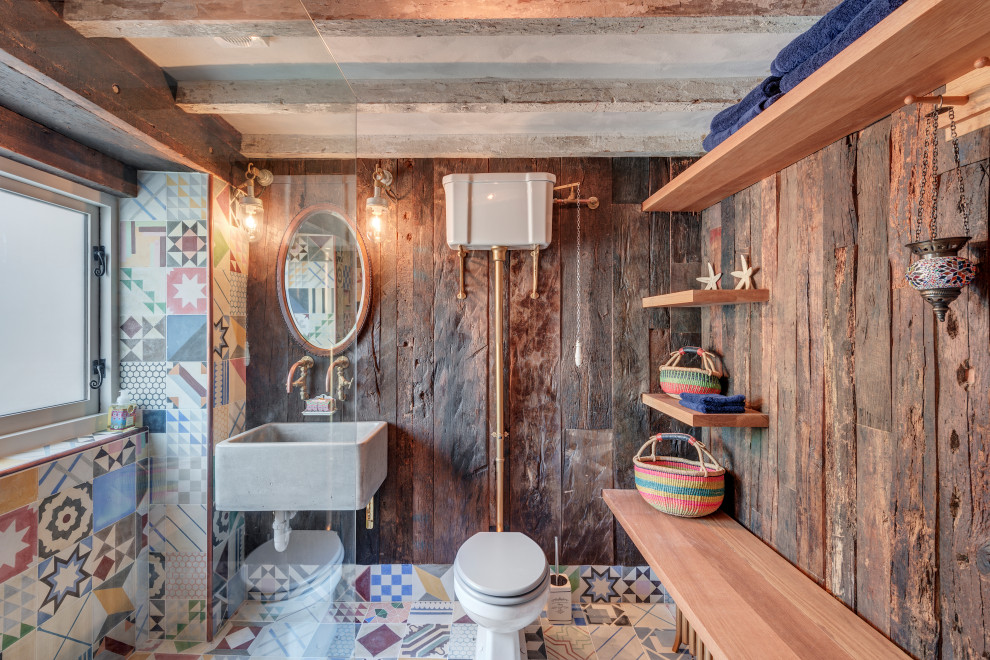 На фото: большая ванная комната в стиле кантри с раздельным унитазом, коричневыми стенами, подвесной раковиной, разноцветным полом, тумбой под одну раковину и деревянными стенами с