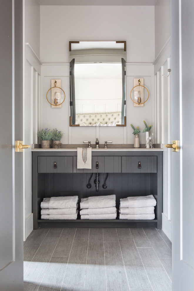 Imagen de cuarto de baño tradicional con puertas de armario grises, paredes grises, suelo gris y encimeras beige
