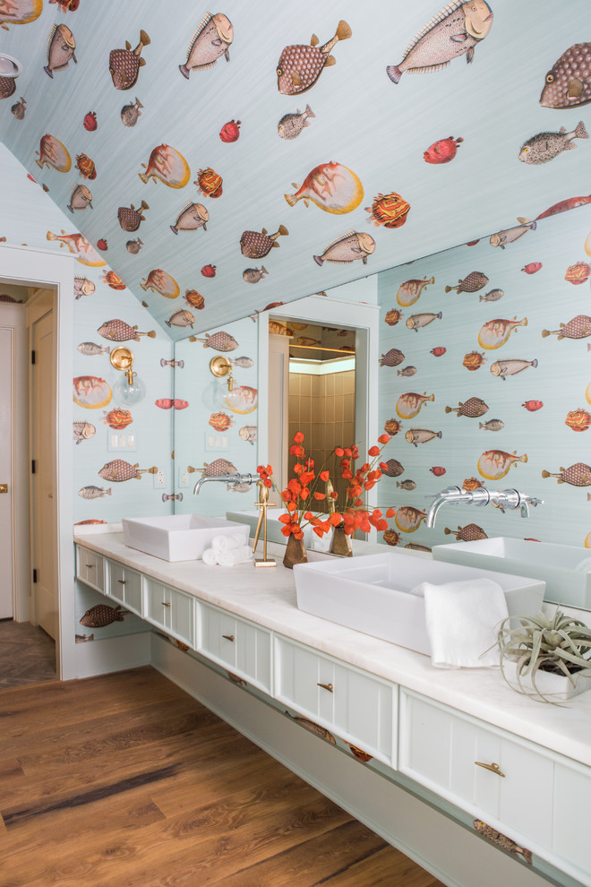 Inredning av ett klassiskt mellanstort vit vitt badrum, med luckor med infälld panel, grå skåp, flerfärgade väggar, mellanmörkt trägolv, ett fristående handfat och brunt golv