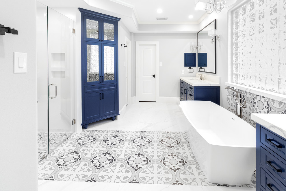 Idéer för att renovera ett mellanstort vintage vit vitt en-suite badrum, med möbel-liknande, blå skåp, ett fristående badkar, en kantlös dusch, en toalettstol med hel cisternkåpa, vit kakel, keramikplattor, grå väggar, klinkergolv i keramik, ett undermonterad handfat, bänkskiva i kvarts, vitt golv och dusch med gångjärnsdörr