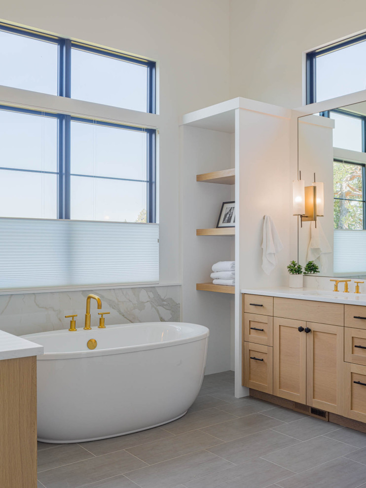 Beach style master multicolored tile and marble tile marble floor, white floor, double-sink and vaulted ceiling bathroom photo in Seattle with recessed-panel cabinets, medium tone wood cabinets, a one-piece toilet, white walls, an undermount sink, marble countertops, a hinged shower door, white countertops and a built-in vanity