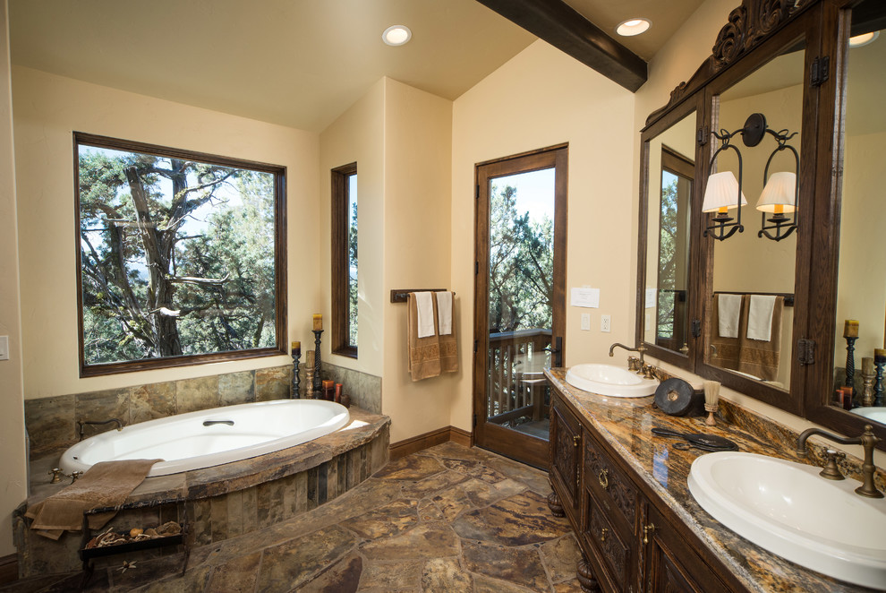 Inspiration for a large rustic master slate floor bathroom remodel in Other with a drop-in sink, furniture-like cabinets, dark wood cabinets, granite countertops and a two-piece toilet
