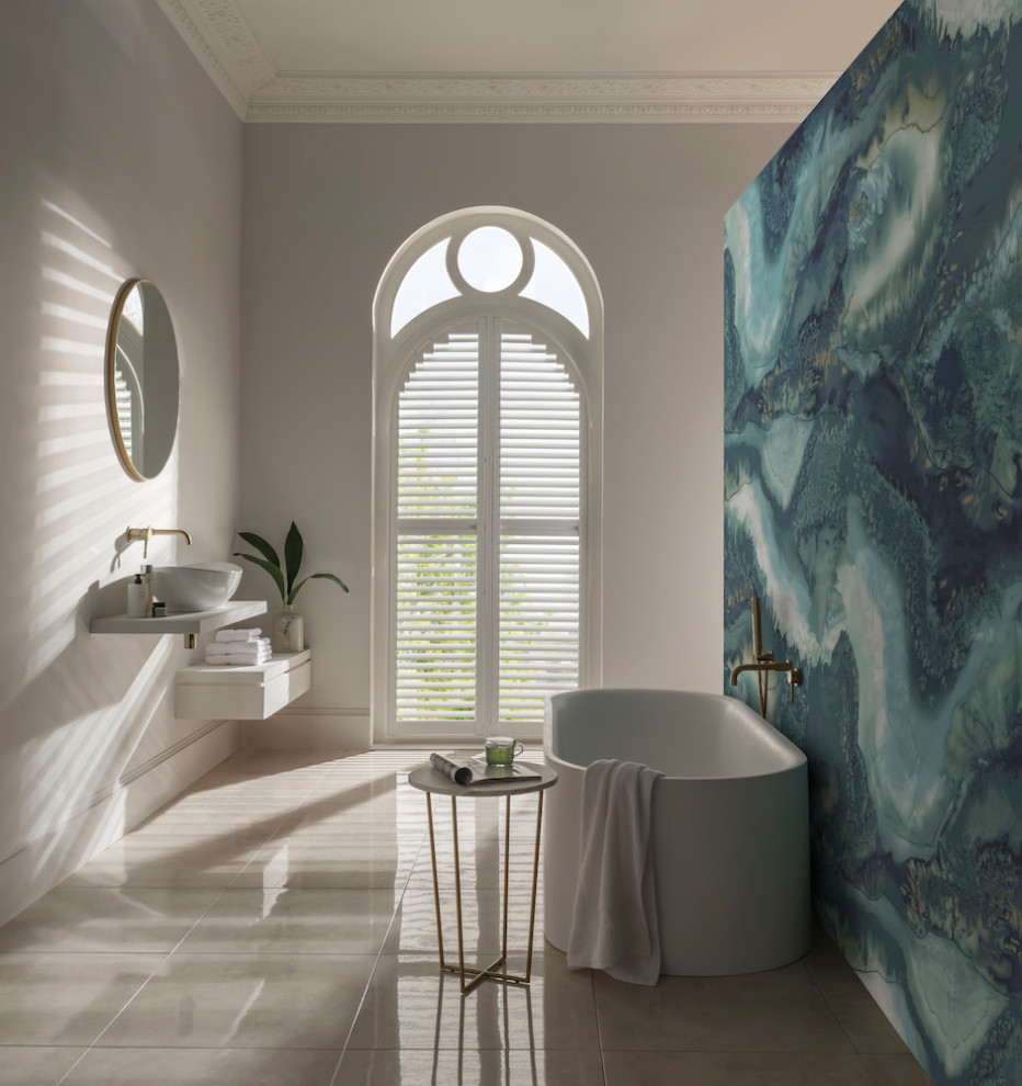 Réalisation d'une salle de bain design avec une baignoire indépendante, un sol en ardoise, meuble simple vasque et du papier peint.