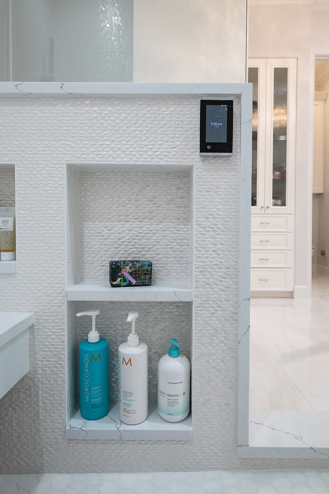 Идея дизайна: большая главная ванная комната в стиле неоклассика (современная классика) с фасадами с выступающей филенкой, белыми фасадами, накладной ванной, двойным душем, унитазом-моноблоком, белой плиткой, керамогранитной плиткой, серыми стенами, мраморным полом, врезной раковиной, стеклянной столешницей, белым полом, душем с распашными дверями и белой столешницей
