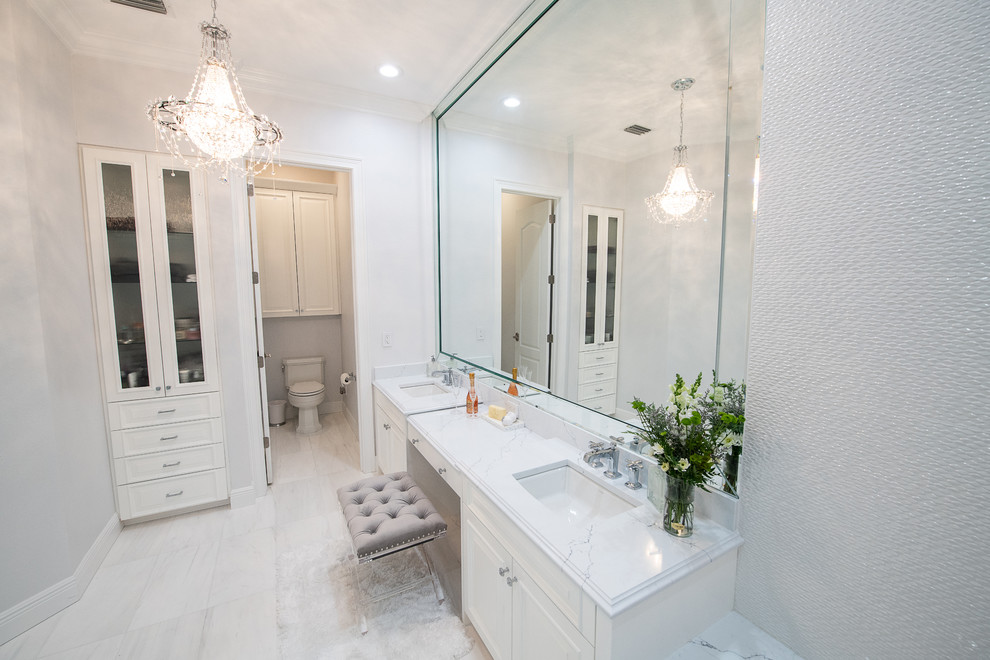 Источник вдохновения для домашнего уюта: большая главная ванная комната в стиле неоклассика (современная классика) с фасадами с выступающей филенкой, белыми фасадами, накладной ванной, двойным душем, унитазом-моноблоком, белой плиткой, керамогранитной плиткой, серыми стенами, мраморным полом, врезной раковиной, стеклянной столешницей, белым полом, душем с распашными дверями и белой столешницей