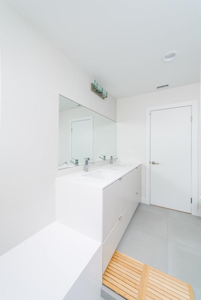 Inredning av ett modernt stort badrum med dusch, med ett undermonterad handfat, släta luckor, grå skåp, bänkskiva i kvarts, en öppen dusch, vit kakel, keramikplattor, vita väggar och klinkergolv i porslin