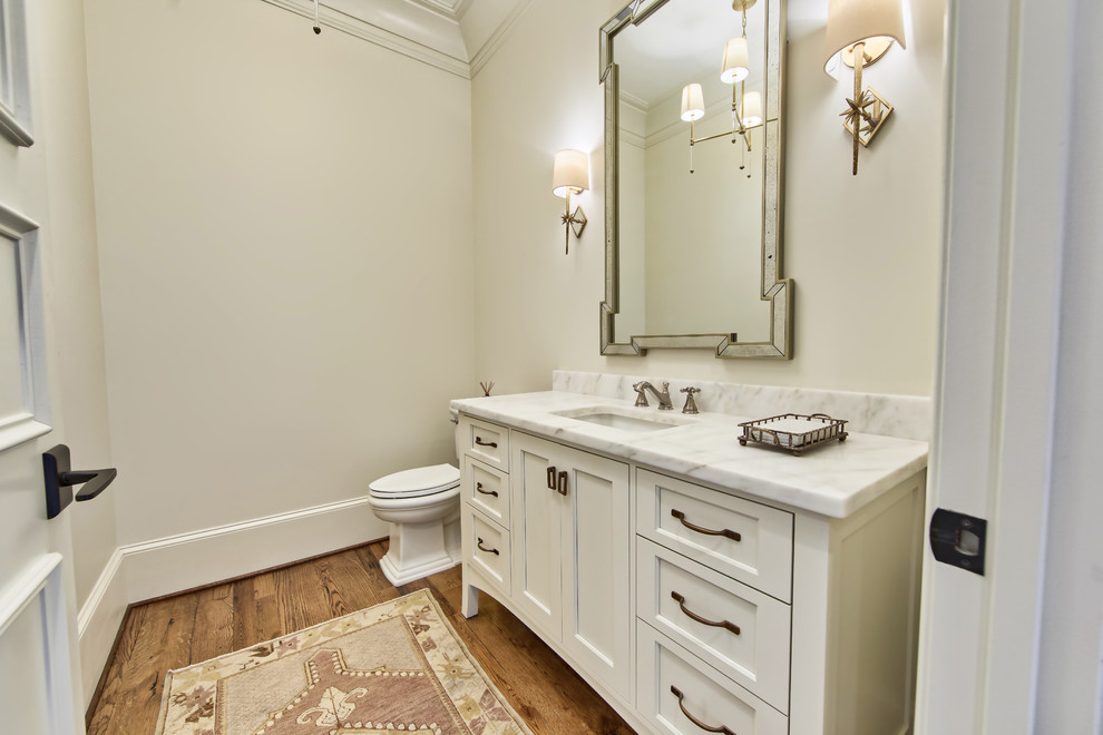 Foto di una stanza da bagno con doccia tradizionale di medie dimensioni con consolle stile comò, ante bianche, WC a due pezzi, pareti bianche, pavimento in legno massello medio, lavabo sottopiano e top in marmo