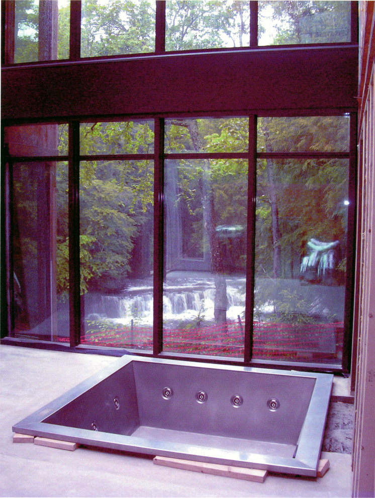 Foto di una stanza da bagno moderna con vasca idromassaggio e piastrelle in pietra