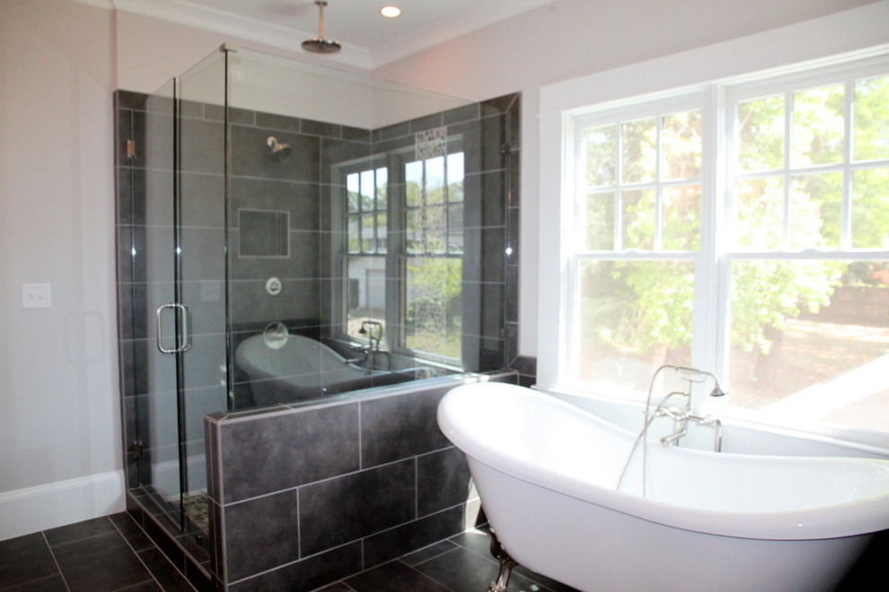 Cette photo montre une salle de bain principale chic de taille moyenne avec une baignoire indépendante, une douche d'angle, un mur beige, un sol en ardoise, un sol gris et une cabine de douche à porte battante.