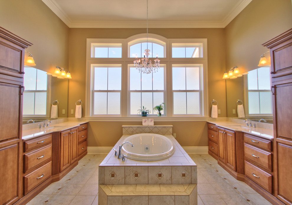 Inspiration for a mid-sized timeless master beige tile, brown tile, white tile and ceramic tile ceramic tile drop-in bathtub remodel in New Orleans with raised-panel cabinets, medium tone wood cabinets, beige walls, an undermount sink and quartzite countertops