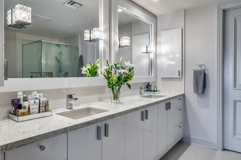 Inspiration för mellanstora moderna en-suite badrum, med släta luckor, vita skåp, vit kakel, keramikplattor och granitbänkskiva