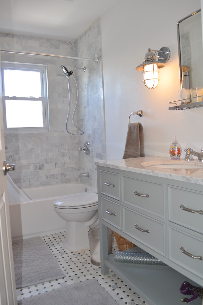 Inspiration for a small coastal tub/shower combo remodel in Tampa with beaded inset cabinets, gray cabinets, a one-piece toilet, white walls and a drop-in sink