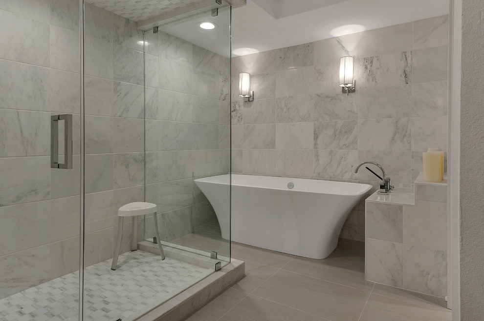 Идея дизайна: большая главная ванная комната в стиле неоклассика (современная классика) с отдельно стоящей ванной, угловым душем, белой плиткой, каменной плиткой, серыми стенами и полом из керамогранита