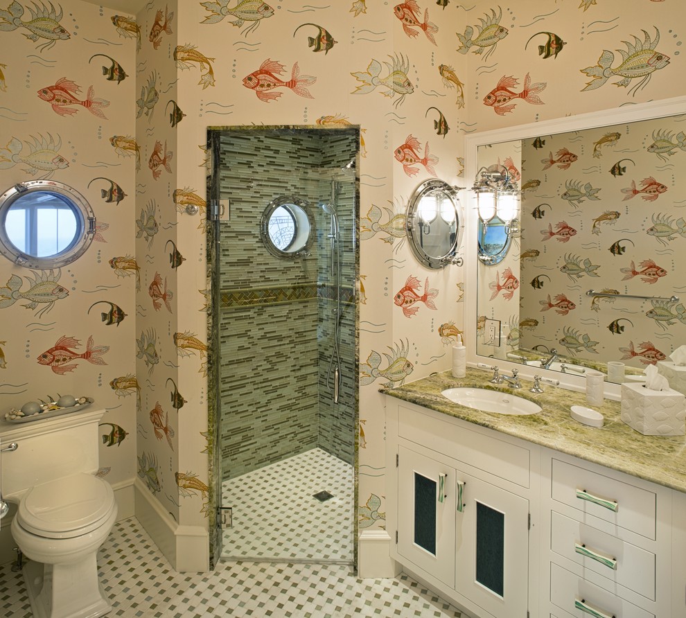 Aménagement d'une salle de bain bord de mer avec une douche à l'italienne et un plan de toilette en marbre.