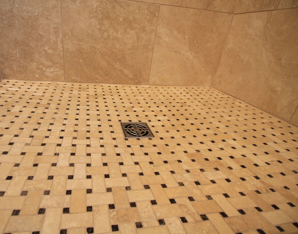 Cette image montre une salle de bain principale marine de taille moyenne avec un lavabo encastré, un placard à porte shaker, des portes de placard bleues, un plan de toilette en surface solide, une baignoire sur pieds, une douche d'angle, WC séparés, un carrelage beige, un carrelage de pierre, un mur beige et un sol en carrelage de porcelaine.