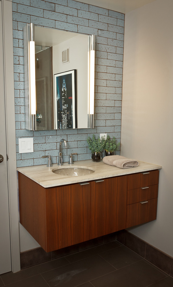 Diseño de cuarto de baño actual con lavabo bajoencimera, armarios con paneles lisos, puertas de armario de madera oscura, baldosas y/o azulejos azules y baldosas y/o azulejos de cemento