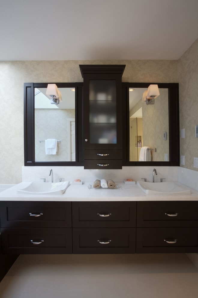На фото: ванная комната в классическом стиле с накладной раковиной, темными деревянными фасадами, столешницей из искусственного кварца и унитазом-моноблоком